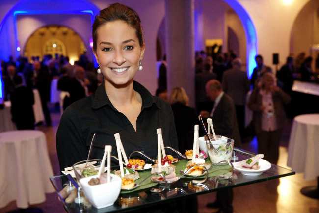 Eine Servicekraft, die ein Tablet mit Essen hält